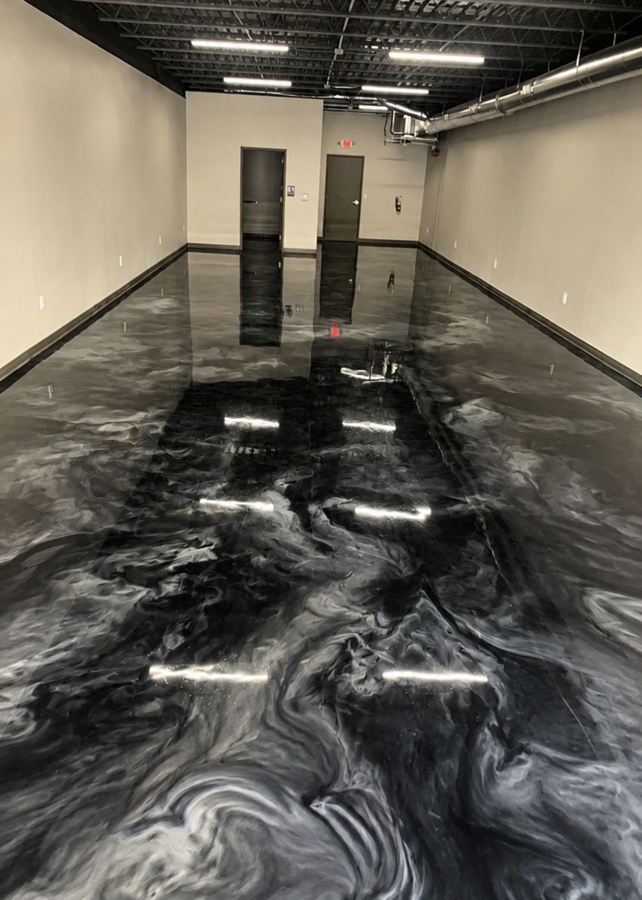 Corridor with a black and white metallic epoxy floor polished to a mirror finish